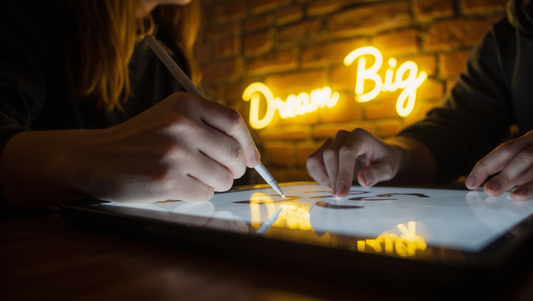 A designer uses a tablet to design your own neon sign, showing the digital mockup next to the finished, glowing product.