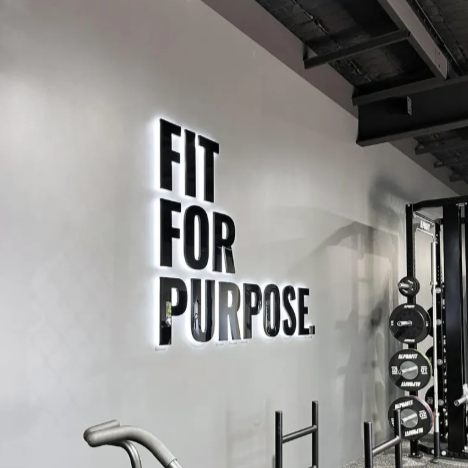 Gym interior with 'Fit for Purpose' motivational quote on the wall.