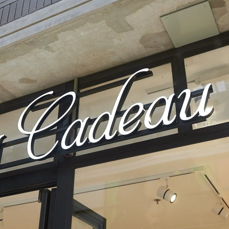 Storefront with 'Cadeau' sign on a building exterior